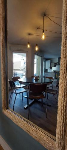 une salle à manger avec une table et des chaises dans un miroir dans l'établissement L'embarcadère Evian - Leman Odyssey, à Évian-les-Bains