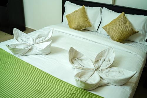 a white bed with two white bows on it at Caravan holiday homes Vythiri in Vythiri