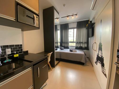 uma cozinha e um quarto com uma cama num quarto em Studio moderno a 5min a pé do Allianz Parque em São Paulo