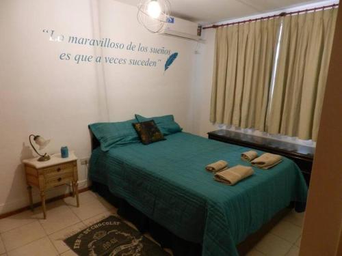 - une chambre avec un lit et une couette verte dans l'établissement Viví Rosario, à Rosario
