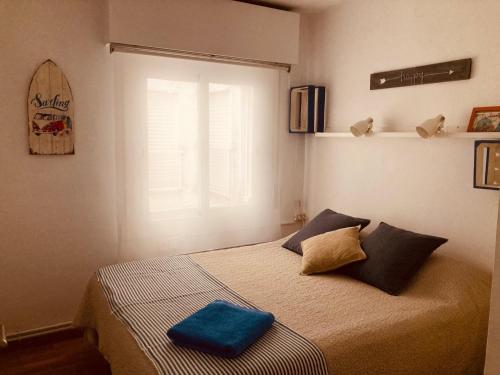 a bedroom with a bed with a blue pillow on it at Can Carlota in San Pol de Mar