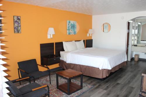 Habitación de hotel con cama y silla en Americas Best Value Inn & Suites Williamstown, en Williamstown