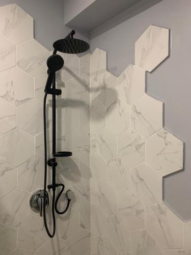 a shower in a bathroom with white tiles at Ajami Guest House in Tel Aviv