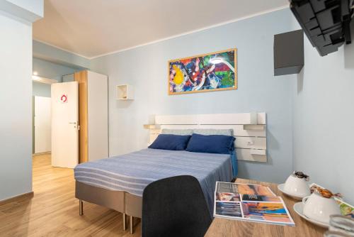 um pequeno quarto com uma cama e uma mesa em RomeCookSea Guesthouse em Lido di Ostia