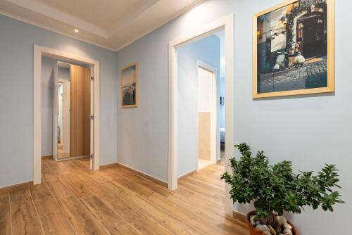 a hallway with white walls and a plant in a vase at RomeCookSea Guest House in Lido di Ostia