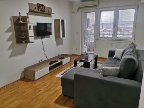 - un salon avec un canapé et une télévision dans l'établissement VD Apartment, à Skopje