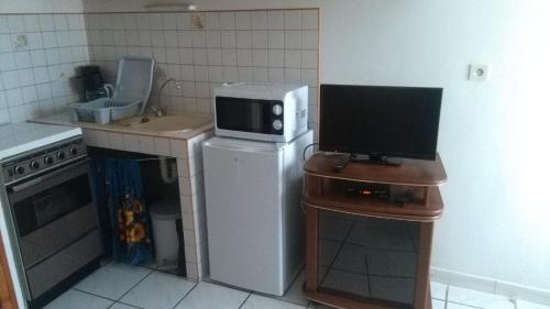 a small kitchen with a microwave on top of a refrigerator at Mireille in Castellane