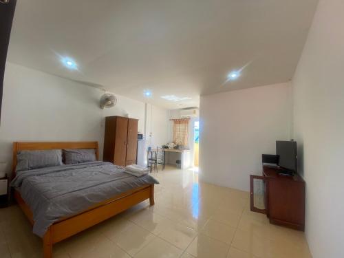 1 dormitorio con 1 cama y TV de pantalla plana en Bangtao Corner, en Bang Tao Beach