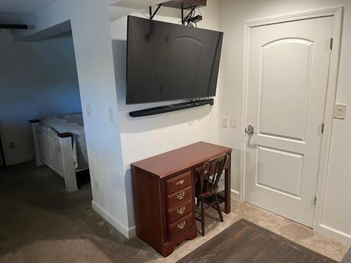 a room with a tv on a wall with a wooden desk at Apartment in the Country in Etowah
