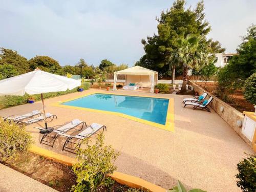 a swimming pool with chairs and an umbrella at Bonita Casa con piscina privada y amplio jardin in Sant Francesc de s'Estany