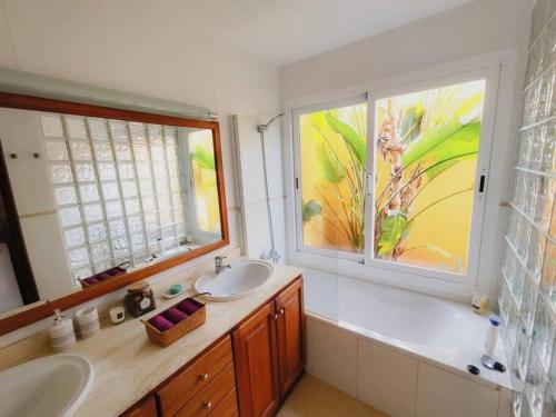 ein Badezimmer mit zwei Waschbecken und einem großen Fenster in der Unterkunft Bonita Casa con piscina privada y amplio jardin in Sant Francesc de s'Estany