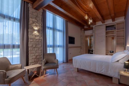 a bedroom with a bed and chairs in a room at Il Filo Rosso B&B in Abano Terme