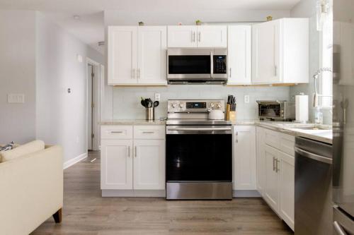 a kitchen with white cabinets and a black dishwasher at Luxury 3BD Condo in the heart of Providence in Providence