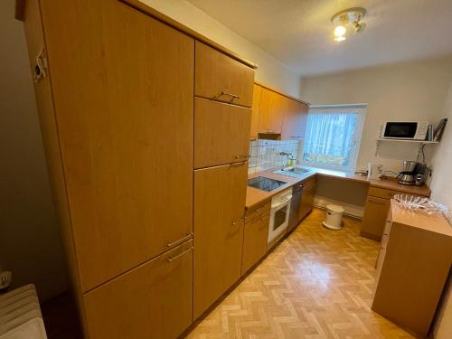 a small kitchen with wooden cabinets and a sink at Pension Bärbel Neelen in Hameln