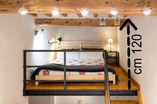 Letto a castello in una camera con muro di mattoni di Il nido - Cozy studio apartment in Santa Croce a Firenze