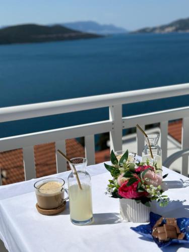 a table with a white table cloth with flowers and drinks at Villa Senka in Neum