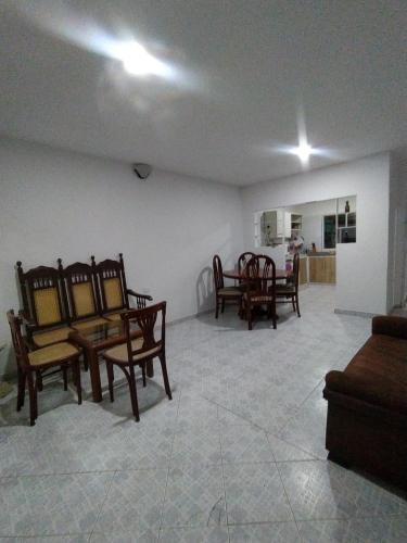 ein Wohnzimmer mit Holzstühlen und einem Tisch in der Unterkunft Casa Bondigua in Santa Marta