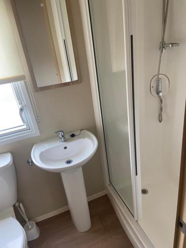 a bathroom with a toilet and a sink and a shower at The Oakley golden sands rhyl in Kinmel Bay
