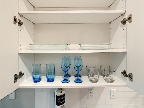 a row of blue glasses sitting on a shelf at King Bed, Great Amenities, And Disney Calling You in Kissimmee