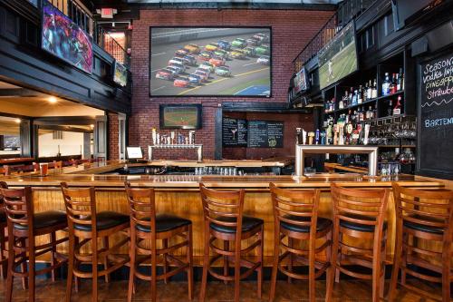 a bar with wooden chairs and a large screen at Portside Tavern in Hyannis