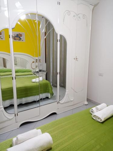 a bedroom with a large mirror and a green rug at Casa Vacanze Mimose in Palinuro