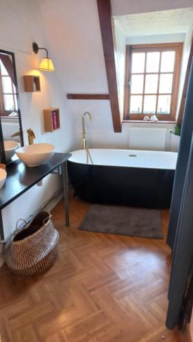 a bathroom with a black tub and a sink at Gîte L'Escalier des Rêves - Rouen in Le Mesnil-Esnard