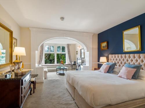 a bedroom with a large bed with a blue wall at Cashel House Hotel in Roundstone