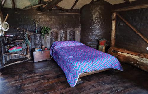 um quarto com uma cama num quarto de madeira em Allpa Wasi - Casa Suaya La Esperanza em Ibarra