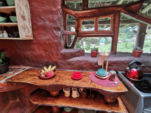 uma pequena cozinha com uma mesa de madeira e um fogão em Allpa Wasi - Casa Suaya La Esperanza em Ibarra