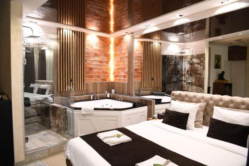 a bathroom with two beds and a bath tub at Design Apartment GRAND SPA LUX 4 STAR "MALIBU" Completely PRIVATE Wellness & Spa FREE INCLUDED Jacuzzi & Salt Wall & Fire place & 3D Ceilings & Business WiFi & NETFLIX & LED Lights & Keyless code entry & FULL SMART APP & SECURE 2 Parking place in Ćuprija
