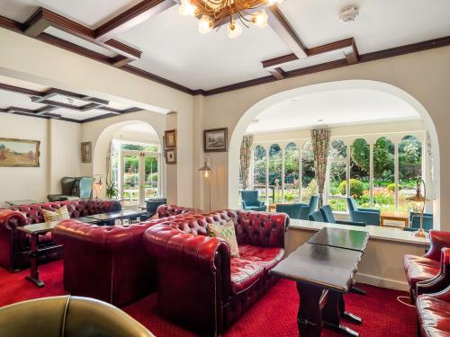 a living room with leather couches and chairs at Cashel House Hotel in Roundstone