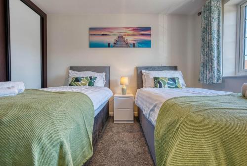 a bedroom with two beds and a window at Skelhorn House in Cosford