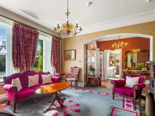 a living room with a purple couch and a table at Cashel House Hotel in Roundstone