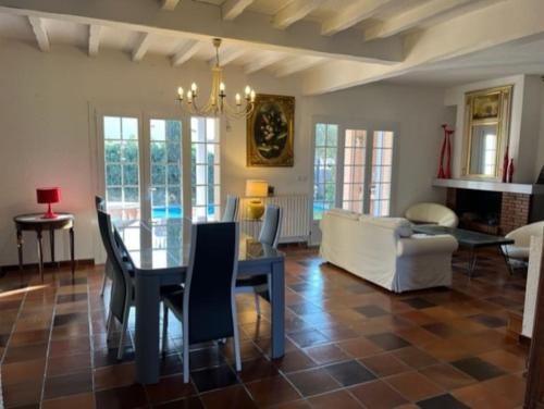 ein Esszimmer und ein Wohnzimmer mit einem Tisch und Stühlen in der Unterkunft Jolie Maison Piscine 8 mn à Pied du centre et Plage in Canet-en-Roussillon