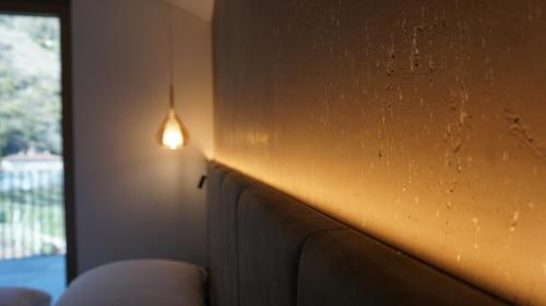 a light on a wall next to a couch at Apartsuites Rosengarten in Lagundo