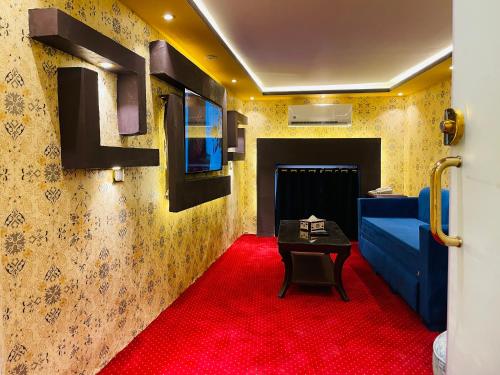 a room with a red carpet and a blue couch at Cairo Inn in Cairo