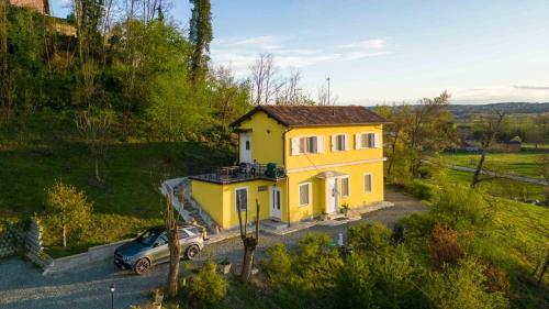 ein gelbes Haus mit einem davor geparkt in der Unterkunft Villa Flora di Capriata d'orba in Predosa