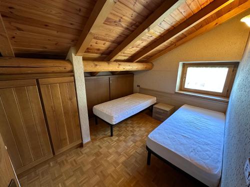 ヴァルディデントロにあるBaita del Cantonのベッド2台と窓が備わる小さな客室です。