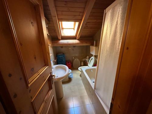 a bathroom with a sink and a tub and a toilet at Baita del Canton in Valdidentro