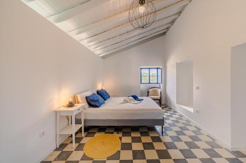 ein Schlafzimmer mit einem Bett und einem karierten Boden in der Unterkunft Aroucas Turismo e Natureza in Castro Marim