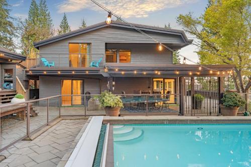 a house with a swimming pool in front of a house at Grouse Cheerful large private bedroom, bath, shared deck, pool, hot tub in North Vancouver