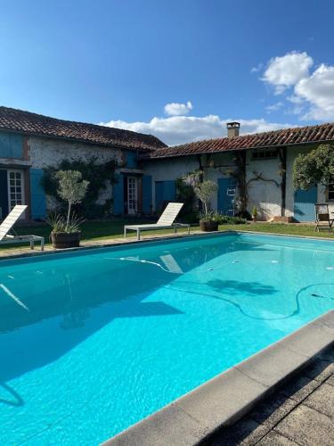 une grande piscine bleue devant une maison dans l'établissement Domaine Du Tafiart Maison Complète, à Sarron