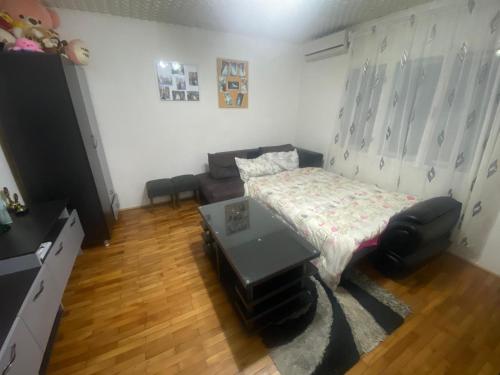 uma sala de estar com uma cama e uma mesa em Iliovski Inn - Just Like Home em Prilepo