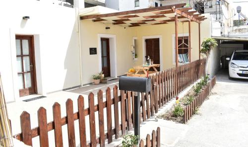 a wooden fence in front of a house at Raeti Cretan Guesthouse in Moírai