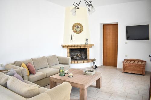 a living room with a couch and a fireplace at Raeti Cretan Guesthouse in Moírai