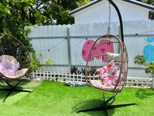 two swings in a yard with grass and a fence at Art Graffiti in Miami