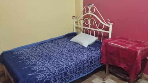 een slaapkamer met een bed en een tafel met een sprei bij DEPA OSAMA in Ayacucho