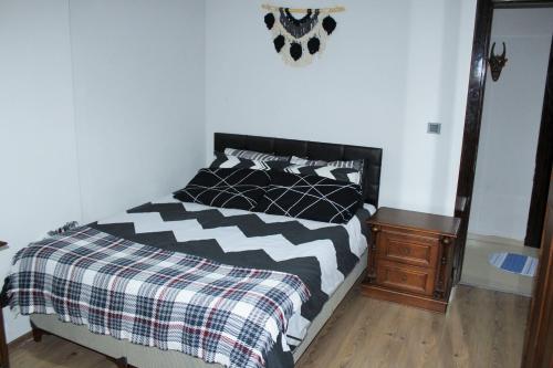 a bedroom with a black and white bed and a nightstand at Roni in Esenyurt