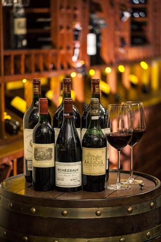 a group of wine bottles and glasses on a barrel at Tonino Lamborghini Hotel Suzhou in Suzhou
