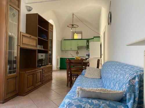 ein Wohnzimmer mit einem Sofa und einer Küche in der Unterkunft casa 102 in Finale Ligure